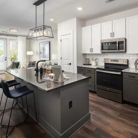 Two-tone kitchen cabinets and island with modern pendant fixture at Camden West Nashville apartments in Nashville, TN