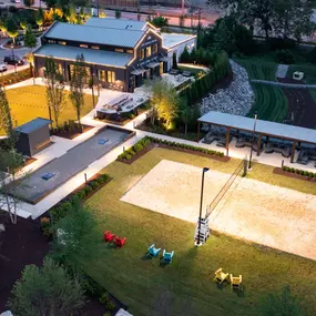 Aerial view of event lawn and sand volleyball court at twilight at Camden West Nashville apartments in Nashville, TN