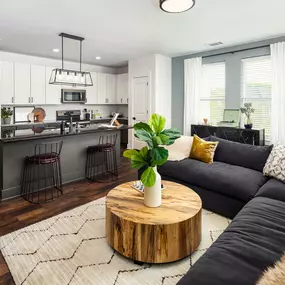 Living room with wood-style flooring and private balcony access at Camden West Nashville apartments in Nashville, TN