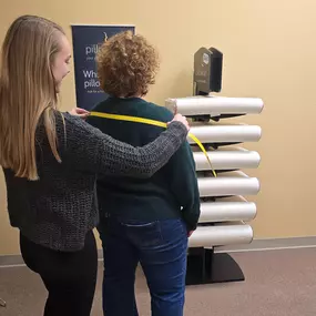 Allison, chiropractic assistant at Healthy Lifestyles Chiropractic measuring a patient for a therapeutic pillow