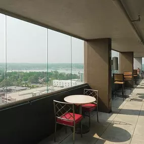 Enclosed exterior walkway with seating and Sloan's Lake in the distance