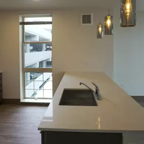 A modern kitchen with a large island and a view of the outside