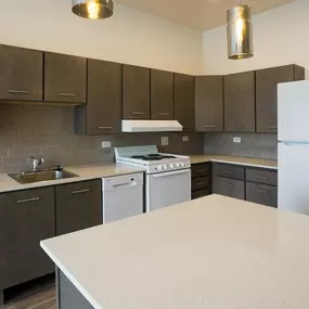 A kitchen with a white counter top and brown cabinets.