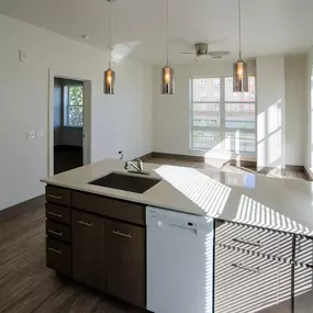 A modern kitchen with a white countertop and wooden cabinets.