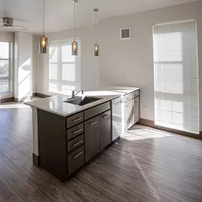 A kitchen with a large island and a fan.