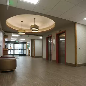 A hallway with a round light fixture and a bench.