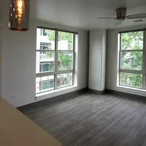 A room with a table, chairs, and a window overlooking a tree-filled area