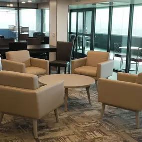 A room with a carpeted floor and a table with chairs