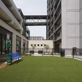 A small grassy area with a bench in front of a building.