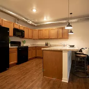 a kitchen with an island and a black refrigerator