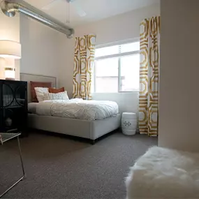a bedroom with a bed and a window with curtains