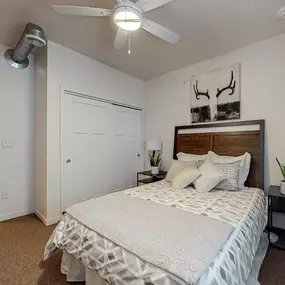 a bedroom with a bed and a ceiling fan