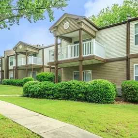 A row of houses with green bushes in front.