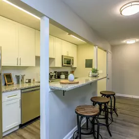 A kitchen with white cabinets and a refrigerator.
