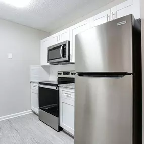 A kitchen with a stainless steel refrigerator, microwave, oven, and dishwasher.
