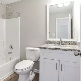 A white bathroom with a toilet, sink, and bathtub.