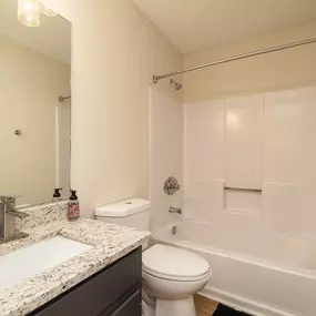 A white bathroom with a sink, toilet, and bathtub.