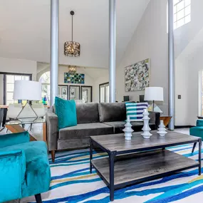 a living room with blue chairs and a gray couch