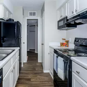 a kitchen with black appliances and white cabinets