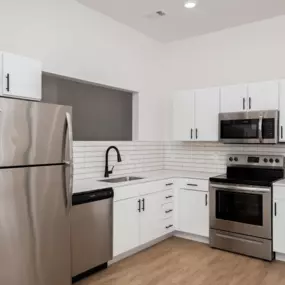A modern kitchen with a stainless steel refrigerator and oven.