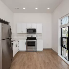 A modern kitchen with stainless steel appliances and white cabinets.