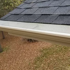 A roof gutter guard installed to prevent debris buildup while allowing water to flow freely, reducing maintenance and improving drainage efficiency.