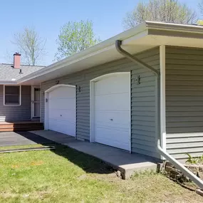 A single-story home with a seamless white roof gutter system along the edges. The gutters and downspouts are well-installed, efficiently directing water away from the home’s foundation, protecting the driveway, landscaping, and overall structure.