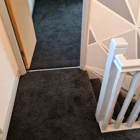 Black carpet fitted in a bedroom and on stairs and landing