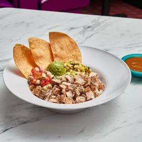 Tex-Mex Burrito Bowl - Mexican rice, jack cheese, grilled peppers & onions, roasted corn salsa, pico de gallo, guacamole & shredded lettuce with fajita chicken or fajita beef. Served with homemade tostada chips & House Salsa.