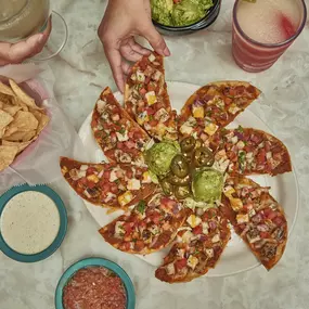 Panchos - Tostada chips, refried beans, cheese and your choice of fajita chicken, fajita beef or seasoned ground beef. Served with lettuce, pico de gallo, jalapeños & guacamole.