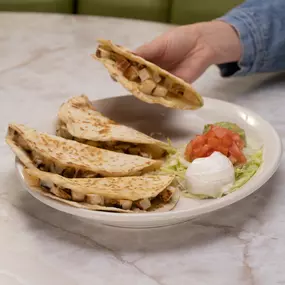 Quesadillas - Flour tortillas stuffed with cheese, green chiles & onion. Served with guacamole, sour cream & tomatoes.