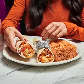 Baja Shrimp Tacos - Flour tortilla with lightly battered and fried shrimp, cilantro, cabbage, pico de gallo & Creamy Jalapeño sauce.