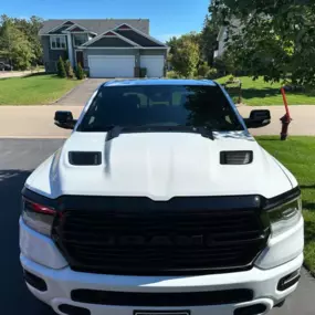 A white RAM 1500 truck after a professional truck detailing and protection service, showcasing a clean, aggressive look with spotless bodywork and grille.