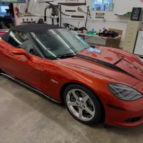 A red Chevrolet Corvette convertible gleaming after our high-performance exterior and interior detailing, highlighting every curve and chrome accent with a flawless finish.