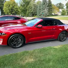 A red Ford Mustang convertible glowing under the sun following our exterior wash and paint protection treatment, perfect for preserving that bold color and sharp style.