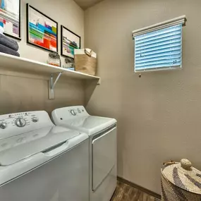Washer and Dryer with a small shelf above them and a small window with blinds