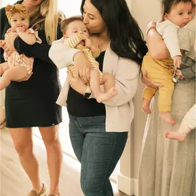 New moms standing together cuddling their infants