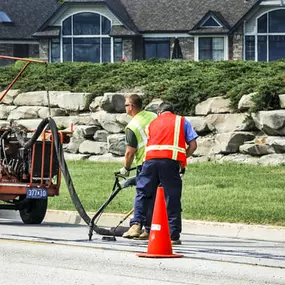 Smooth paving workers using a machine on the asphalt.