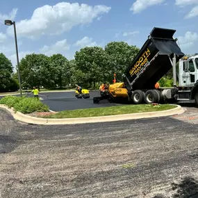 Smooth paving truck dumping material on to the asphalt for the project.