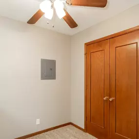 an empty bedroom with a closet and a ceiling fan