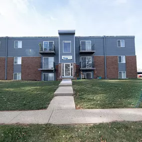 A large apartment complex with a grassy front yard