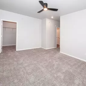 A room with a ceiling fan and carpeted floor