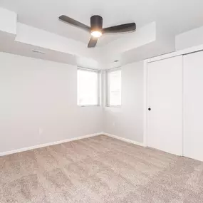 an empty room with a ceiling fan and a closet