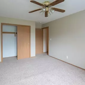 A room with a ceiling fan and carpeted floor