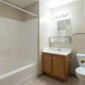 A bathroom with a white tub, sink, and toilet