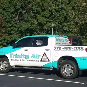 Trinity Air Heating & Air Conditioning van near trees