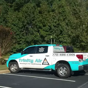 Trinity Air Heating & Air Conditioning van near trees