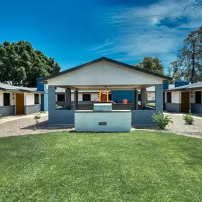 A modern resident clubhouse with a blue roof and a white garage