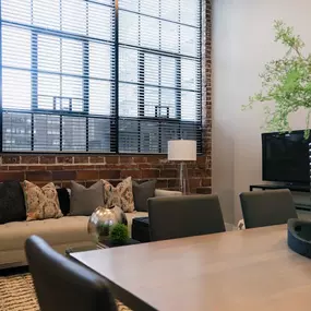 A living room with a brick wall and a wooden table