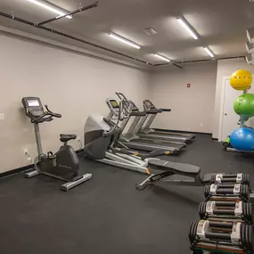 A gym with a treadmill, exercise balls, and resistance bands